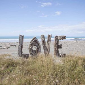 Artistic colour photo print of a human-sized Love sign made of driftwood sitting on Opotiki Beach, New Zealand.