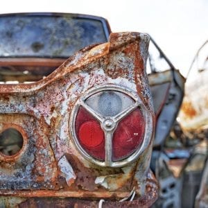 Artistic colour photo of a rusted vintage car headlight at a car wreckage called Smash Palace in Horopito, New Zealand.